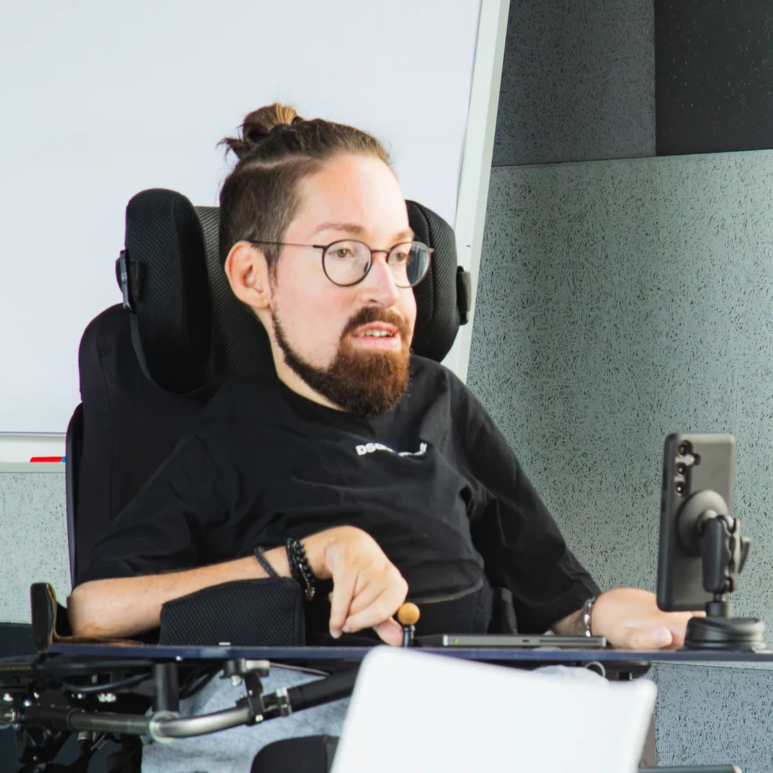 Samuel Blickle im Elektrorollstuhl an seinem Arbeitsplatz